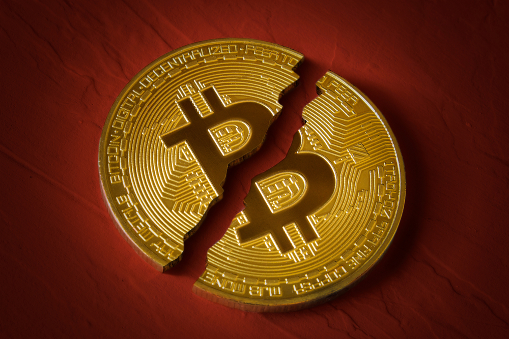 Coin-bitcoin-is-broken-in-half-on-red-background.-The-fall-and-collapse-of-the-course-of-the-crypto-currency-the-ban-on-trade-fall-down-Image