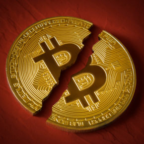 Coin-bitcoin-is-broken-in-half-on-red-background.-The-fall-and-collapse-of-the-course-of-the-crypto-currency-the-ban-on-trade-fall-down-Image